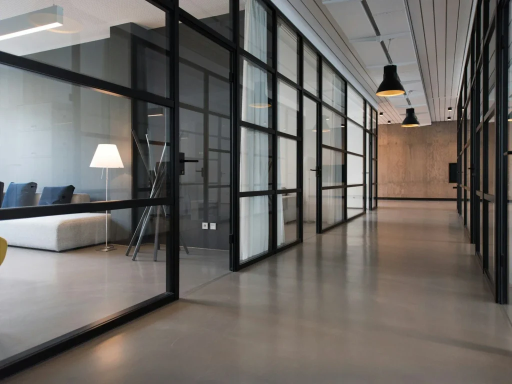 Minimal open-plan office with white desks and glass partitions